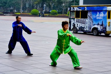 Chinese couple practice Tai Chi in Nanjing Road Shanghai China clipart