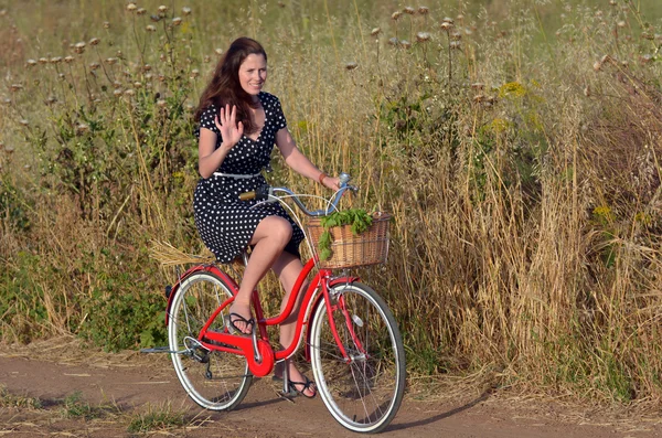 Jovem mulher montando bicicleta vintage — Fotografia de Stock