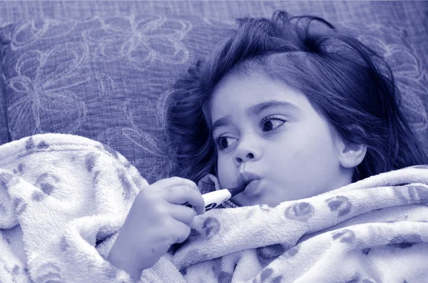 Ziek meisje kind met thermometer in mond — Stockfoto