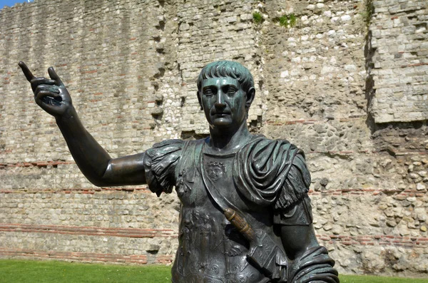 Statue of Trajan in front of a section of the Roman wall, Tower — стокове фото