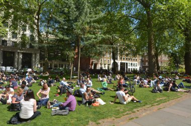 Güneşli gün Londra'nın Soho Meydanı'nda ziyaretçi