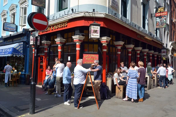 Soho'daki Londra İngiltere'de İngilizce barın önünde içki içiyorum insanlar — Stok fotoğraf