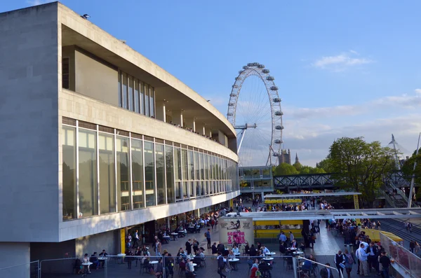Visitors outside the Royal Festival Hall in with London Eye in t — 스톡 사진