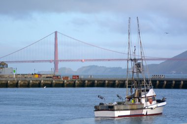 Fishing boat in Fisherman wharf against the Golden Gate Bridge i