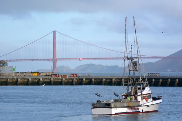 Fishing boat in Fisherman wharf against the Golden Gate Bridge i — Stok fotoğraf