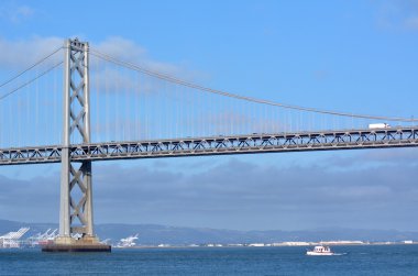 Fishing boat sail under Oakland Bay Bridge