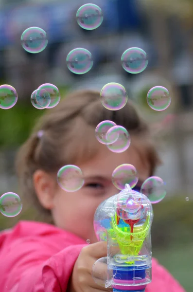 Little child blowing soap bubbles — 图库照片