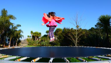 Happy little child dressed up as lady bug buns and jumps on tram