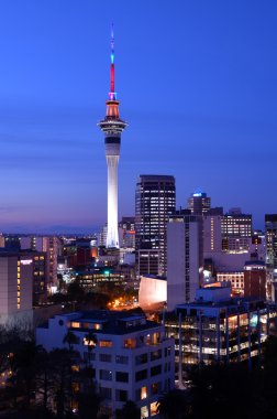 Auckland Sky tower in colors and the financial center skyline