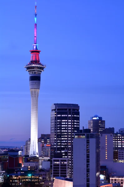 Urban view of Auckland Sky tower in colors at dusk — Stock Photo, Image