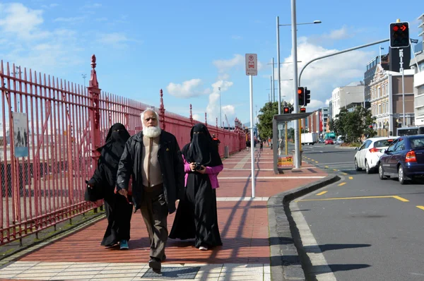 Muslim man walks with two muslim woman with fully body cover (Bu — Stock Photo, Image