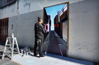 Graffiti artist paint a mural on a wall