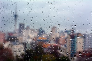 Rain drops falls on a window overlooking Auckland CBD New Zealan