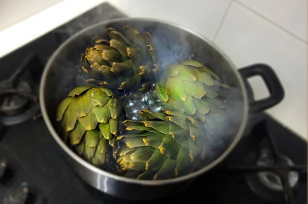 Globe artichokes being cooked in hot water — Stok fotoğraf