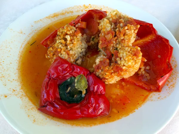 Gevulde rode paprika met opkomst geserveerd op een bord — Stockfoto