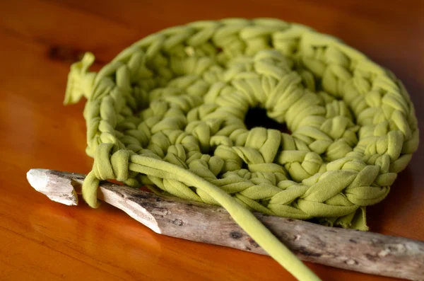 Ручной деревянный крючок для вязания иголки для шитья кусочков зеленой ткани — стоковое фото