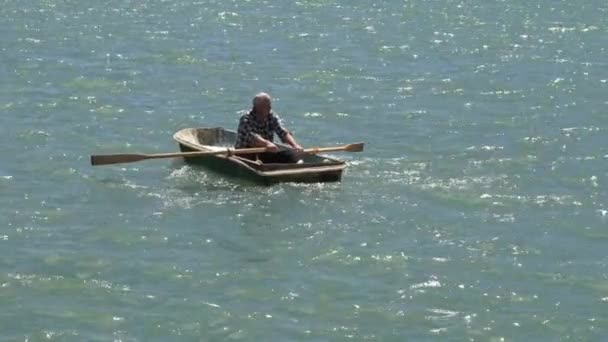 Un homme ramant un bateau à rames en mer — Video