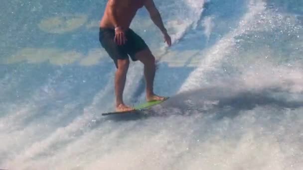Genç adam FlowRider 'da sörf tahtasına biniyor. — Stok video