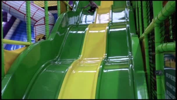 Child slides on a big playground slide — Stock Video