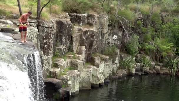 Člověk skáče z Charlieové Rock vodopád Kerikeri Northland Nový Zéland 01 — Stock video