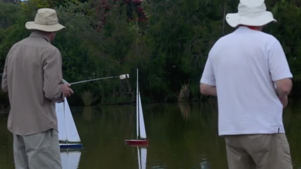 Menschen segeln Fernbedienung segeln Holzjachten in einem Teich 01 — Stockvideo