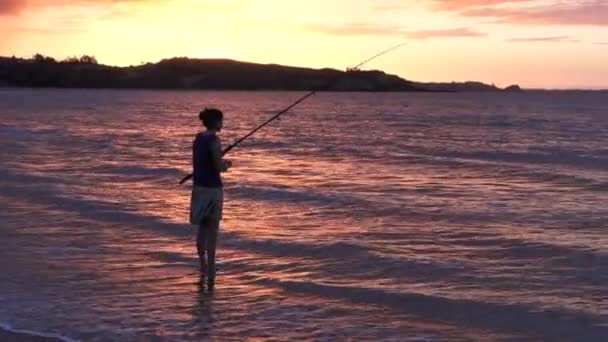 Silhueta de jovem mulher lançando haste de pesca — Vídeo de Stock