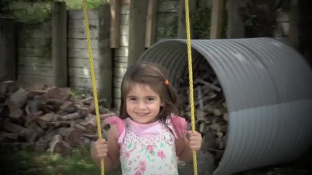 Slow motion of little girl swinging on a swing — стоковое видео