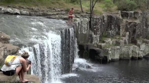 Homem salta de Charlies Rock cachoeira kerikeri Nova Zelândia 02 — Vídeo de Stock