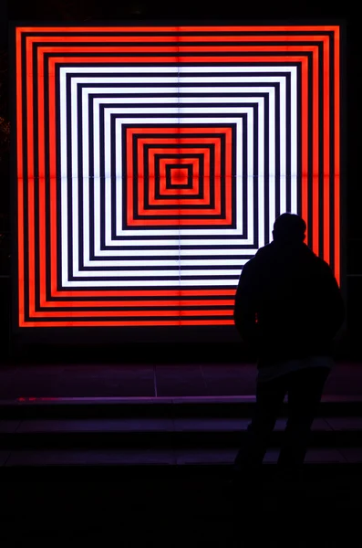 A silhueta de homem olha para uns quadrados luzes de néon — Fotografia de Stock