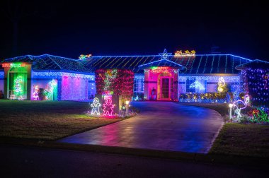 PORT MACQuARIE - 24 DEC 2025: Gece karanlığında yeni yıl süslemeleri olan ev, sık sık kötü şansı uzaklaştırmaya odaklanıyor ve gelecek yıl için iyi şans, ışık ve sıcaklık getiriyor