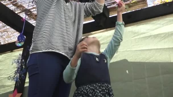 Jewish woman and child decorating Sukkah for the Jewish festival of Sukkot — Video