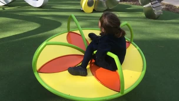 Niño jugar en un carrusel en el patio de recreo — Vídeos de Stock