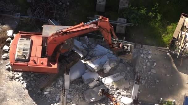 Excavadora en el trabajo destruyendo un muro de hormigón — Vídeo de stock