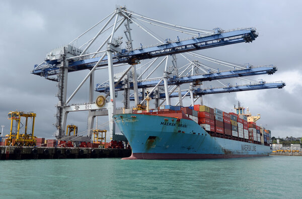 Cargo ship unloading containers in Ports of Auckland New Zealand