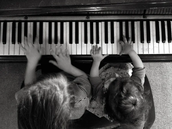 Двое детей играют на фортепиано — стоковое фото