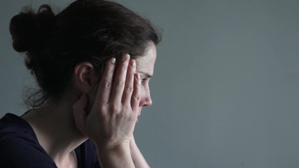 Woman in her thirties sitting at a table upset. — Stock Video