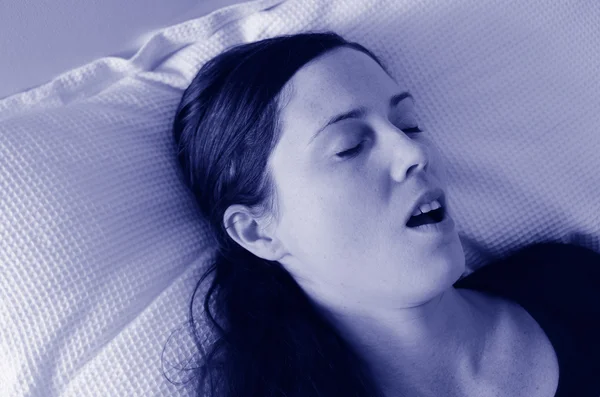 若い女性がベッドでいびきをかくこと — ストック写真