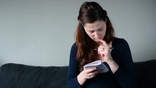 Jeune femme qui pense à faire la liste à la maison — Video