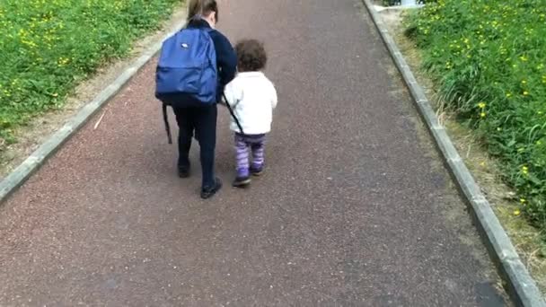 Kleine Schwester geht mit ihrer älteren Schwester zur Schule — Stockvideo