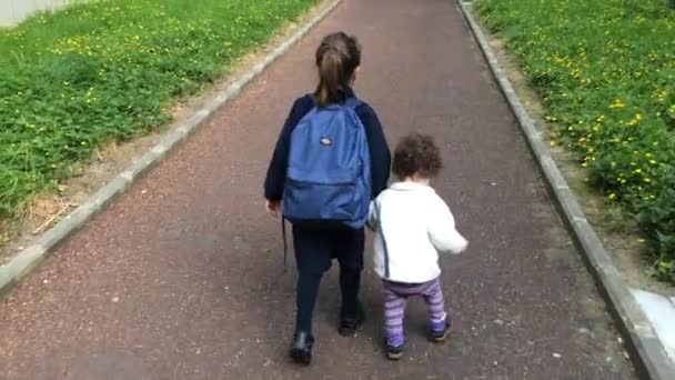 Jonge zus wandelingen met haar oudere zus naar school — Stockvideo