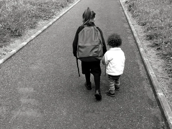 Young sister walks with her older sister to school — Stock Photo, Image