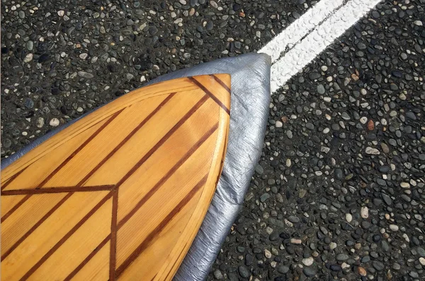 Wooden surf board on a sealed road — Stok fotoğraf