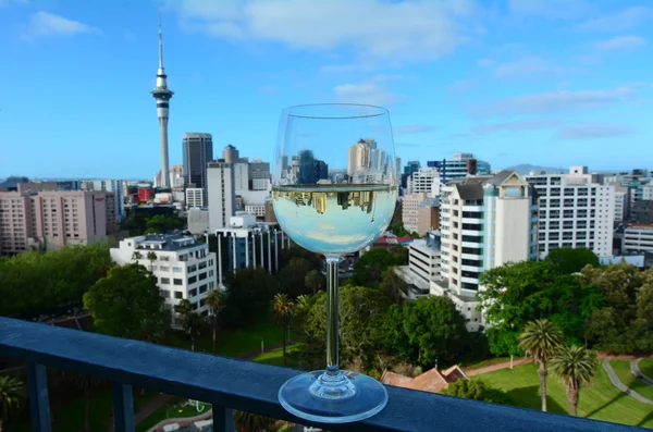 Sauvignon Blanc glass against Auckland skyline — Stock fotografie