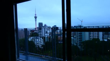 Gece karanlığında Auckland şehir manzarası bakan adam