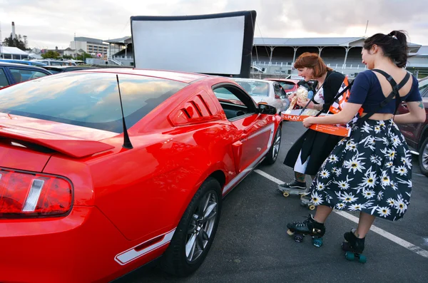 Rullskridsko servitörer försäljning popcorn i Drive-in teater — Stockfoto