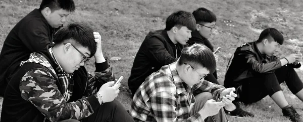 Grupo de hombres chinos utilizando sus teléfonos móviles al aire libre — Foto de Stock