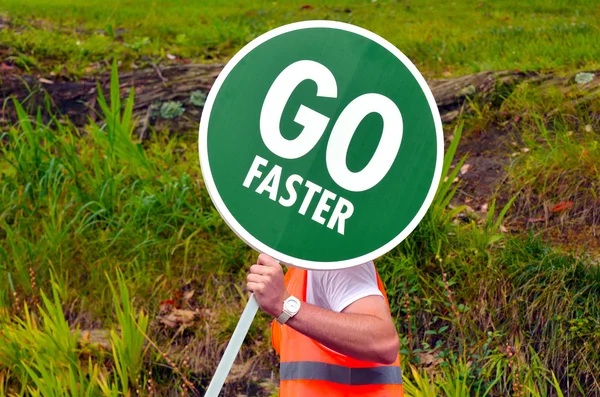 Trabajador de la carretera irreconocible sostiene Go Señalización vial de tráfico más rápido — Foto de Stock