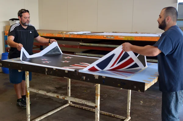 Trabajadores imprimen la bandera nacional de Nueva Zelanda —  Fotos de Stock