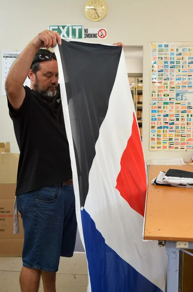 Worker fold the Red Peak flag — Stock Photo, Image