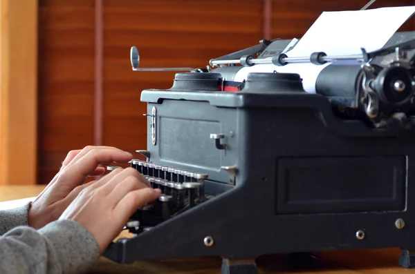Mão de uma jovem escritora escrevendo sobre máquina de escrever antiga — Fotografia de Stock